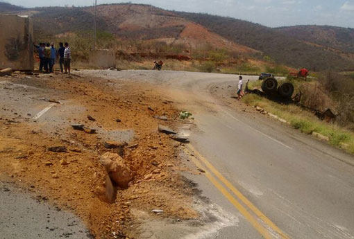 BA-262: carreta bitrem carregada com pedras de mármore capota e provoca estragos no asfalto